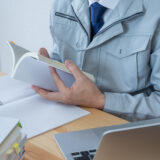 勉強する作業服姿の人